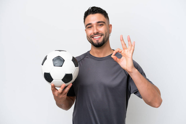 Arabo giovane giocatore di calcio uomo isolato su sfondo bianco mostrando segno ok con le dita - Foto, immagini