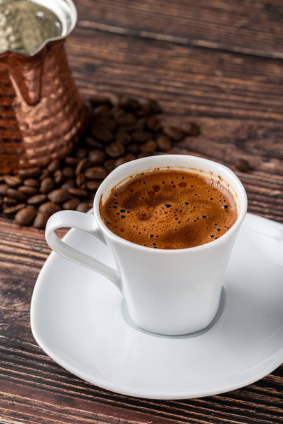 Турецька кава в класичній кавовій чашці з водою і турецькою насолодою на дерев'яному столі. - Фото, зображення