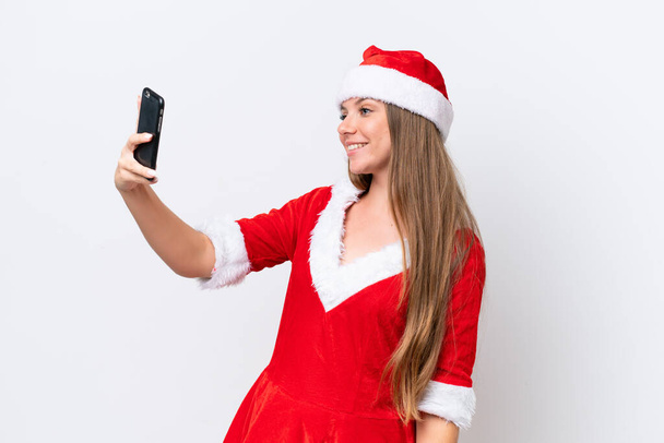 Giovane donna caucasica vestita da mamma noel isolata su sfondo bianco facendo un selfie - Foto, immagini