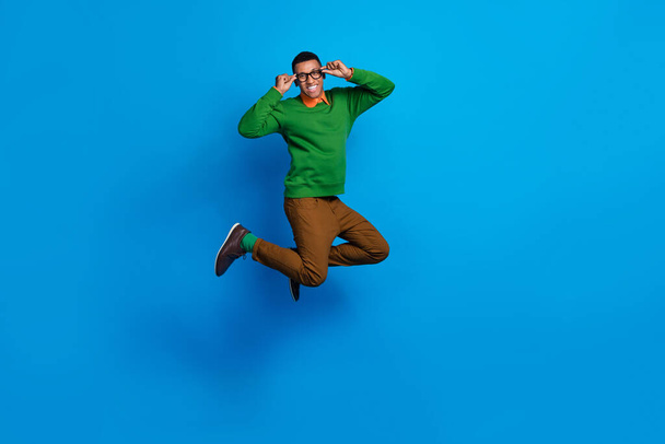 Full body length photo of young excited positive gentleman guy jumping air hold his eyeglasses celebrate weekend isolated on blue color background. - Valokuva, kuva
