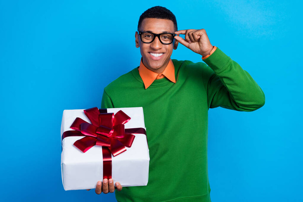 Photo of young confident businessman promotion his best giftbox for low price touch glasses enjoy xmas isolated on blue color background. - Фото, изображение