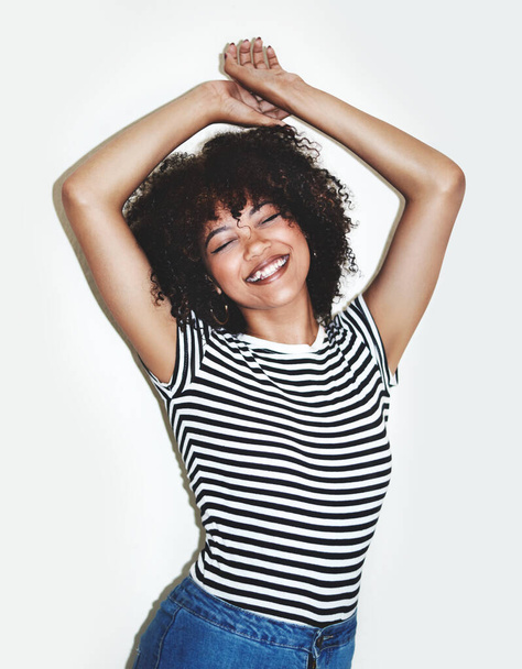 Happy, black woman and smile with dance to relax, confident and trendy with gray studio background. Young female, African American girl and happiness for dancing, natural beauty and excited with joy - Фото, зображення