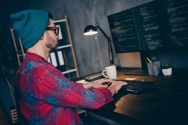 Photo of busy clever coder dressed hat glasses writing javascript modern gadget indoors workplace workstation loft. - Fotografie, Obrázek