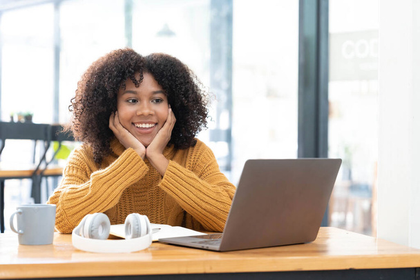Fénykép vidám vidám vidám vegyes fajú nő sárga ingben mosolygós munka laptop talk beszélnek videó hívás online. Okos etnikai nő fülhallgatóban tanul távoli számítógépen otthon. Oktatási koncepció... - Fotó, kép