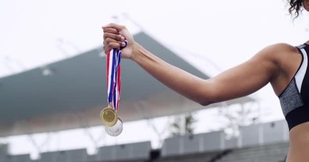 Winner, sports and girl hands with medal prize at champion running competition stadium. Gold, silver and athlete achievement of black woman runner with success, victory and win at event - Footage, Video
