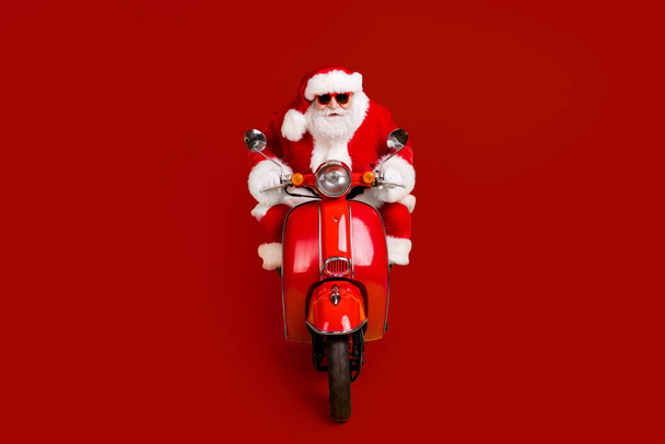 Portrait of his he nice funny fat focused serious Santa St Nicholas driving motor bike traveling highway wintertime rally race fast speed isolated bright vivid shine vibrant yellow color background - Foto, immagini