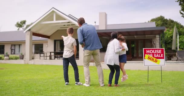 Back, family and homeowner outdoor, on grass and purchased house being happy, relax and quality time. Love, man and woman with kids, children and new home for happiness, bonding and on lawn together - Footage, Video