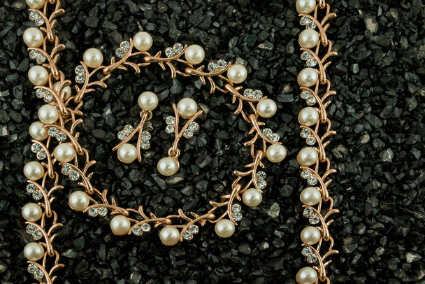 Set de brazalete dorado con diamantes sobre fondo negro - Foto, Imagen