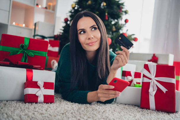 Photo of dreamy sweet girl wear xmas green pullover holding discount card shooping modern device indoors home room. - Fotografie, Obrázek