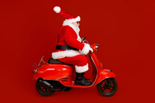 Profile side view of his he nice funny fat thick white-haired Santa riding motor bike fast speed hurry up rush shopping sale hat ball fly isolated bright vivid shine vibrant yellow color background - Fotó, kép