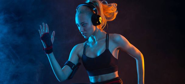 Strong athletic fit woman on black background wearing in the sportswear. Fitness and sport motivation. Download vertical banner for sports website or mobile application. - Fotografie, Obrázek