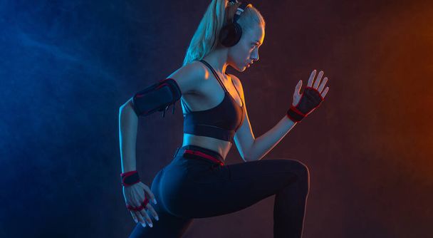 Strong athletic fit woman on black background wearing in the sportswear. Fitness and sport motivation - Valokuva, kuva