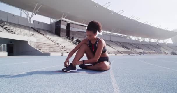 Στάδιο, γυμναστήριο και γυναίκα δένουν τα παπούτσια προετοιμασία για προπόνηση, προπόνηση ή τρέξιμο. Ευεξία, υγεία και γυναίκα από τη Βραζιλία ετοιμάζεται για άσκηση, αθλητισμό ή μαραθώνιο τρέχει σε εξωτερικούς χώρους σε πίστα αγώνων - Πλάνα, βίντεο
