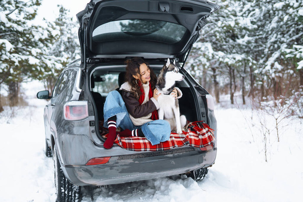Young woman and cute husky dog enjoying and have fun winter holidays among snowy landace. Travel concept. Winter season. - Fotografie, Obrázek