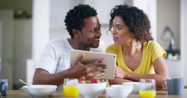 Couple, tablet and technology in a home kitchen with a hug enjoying breakfast food with love and care. Online morning technology of a black woman and man at home looking at recipes on social media. - Footage, Video