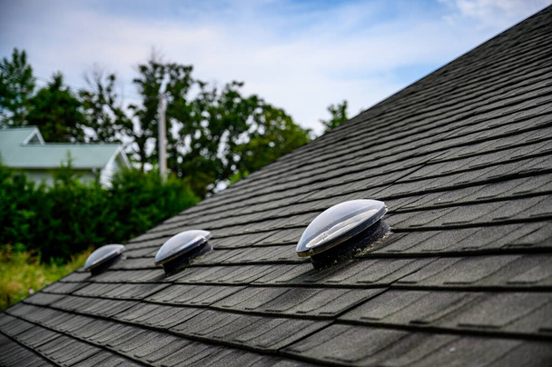Dome shaped solar tube skylight on asphalt shingle roof . High quality photo - Foto, Imagem
