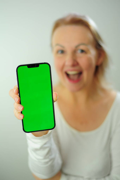 Winning to find what to look for joy happiness different emotions Chroma Key Phone green screen space for advertising Photo of woman in white shirt on a white background Beautiful adult happy woman - Photo, Image