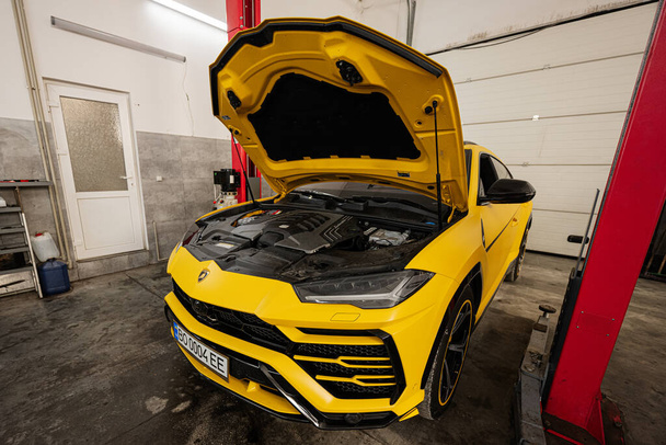 Ternopil, Ukraine- November 11, 2022:  Yellow Lamborghini Urus with open hood in car service station. - Photo, image