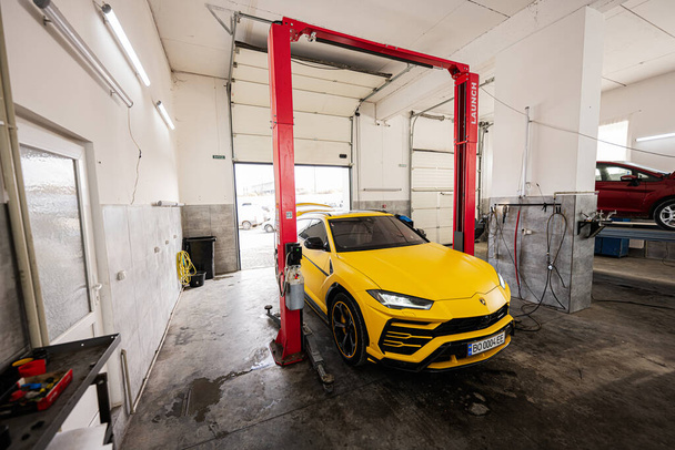 Ternopil, Ukraine- November 11, 2022:  Yellow Lamborghini Urus in car service station. - Fotoğraf, Görsel