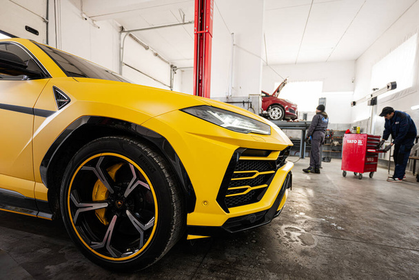 Ternopil, Ucrania- 11 de noviembre de 2022: Lamborghini Urus amarillo en la estación de servicio de automóviles. - Foto, imagen