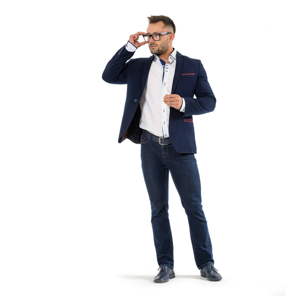 Homme dans une veste d'affaires et des lunettes regarde vers l'espace vide. Il se tient à sa pleine hauteur. - Photo, image