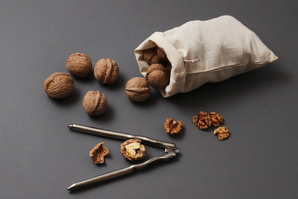 Walnuts pouring out of a bag on a gray background. Shallow depth of field - Фото, зображення
