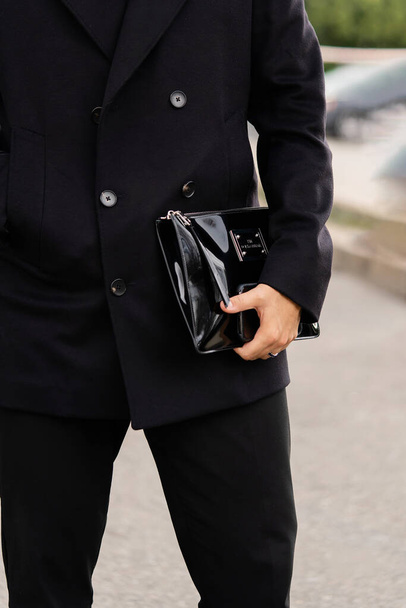 ミラノ、イタリア- 9月25日:ドルチェとガッバーナの黒いニスの入ったバッグを着た男のインフルエンサー。ファッションブロガーの服の詳細、ストリートスタイル. - 写真・画像