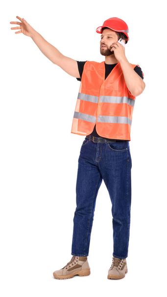 Man in reflective uniform talking on smartphone against white background - Foto, immagini