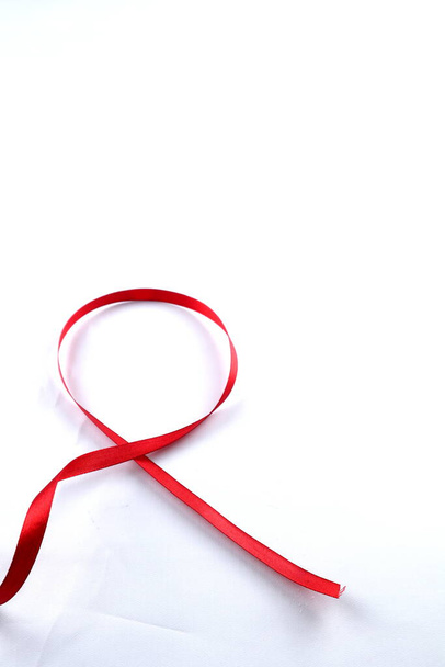 Red Support Ribbon isolated on white background. World aids day and national HIV/AIDS and aging awareness month with red ribbon. copyspace area - Photo, Image
