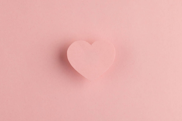 Elevated pink heart shape and shadow on pink background with copy space. Valentine's day, love, romance and celebration concept. - Photo, image