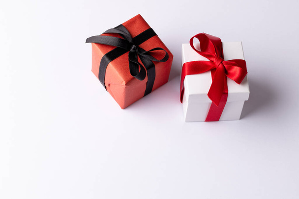 White and red gifts with red and black ribbons, on white background with copy space. Valentine's day, love, romance and celebration concept. - Fotó, kép