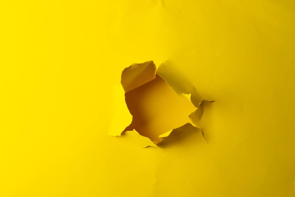 Ripped up piece of yellow paper with copy space on yellow background. Abstract paper texture background and communication concept. - 写真・画像