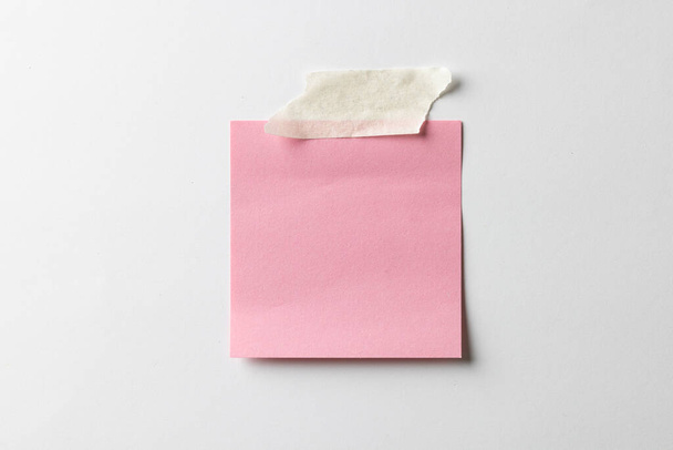 Pink sticky memo note with tape and copy space on white background. Abstract paper texture background and communication concept. - Фото, зображення