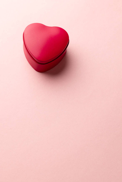 Vertical image of red heart shaped box on pale pink background with copy space. Valentine's day, love, romance and celebration concept. - Foto, imagen