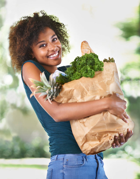 Todo lo que necesita para su nueva y saludable dieta. una atractiva joven que lleva una bolsa de comestibles - Foto, Imagen