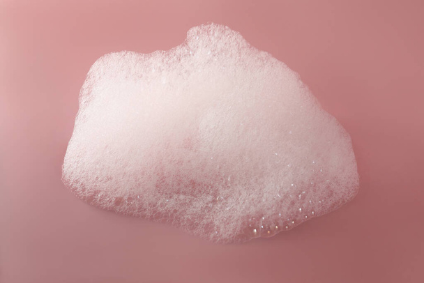 Fluffy bath foam on pink background, top view - Φωτογραφία, εικόνα