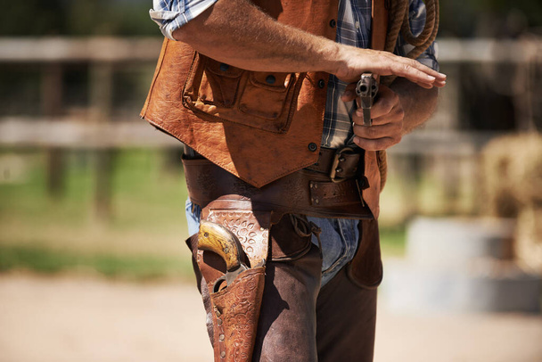 Разбойник с быстрой ничьей. Неузнаваемый ковбой с опущенным пистолетом - Фото, изображение