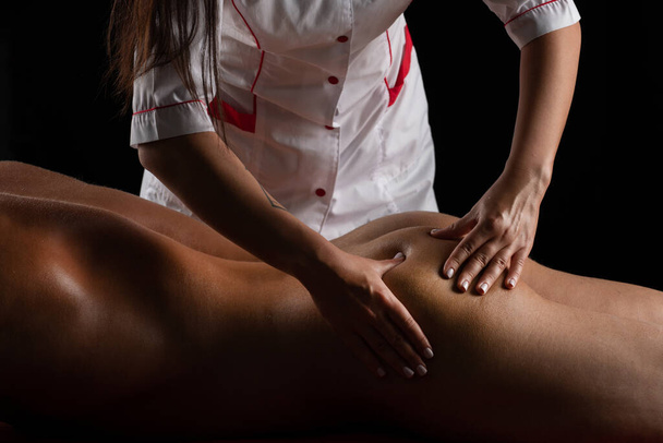 Massage for man close up. Physiotherapist massaging male buttocks. Man relaxing on massage table receiving massage - Фото, зображення