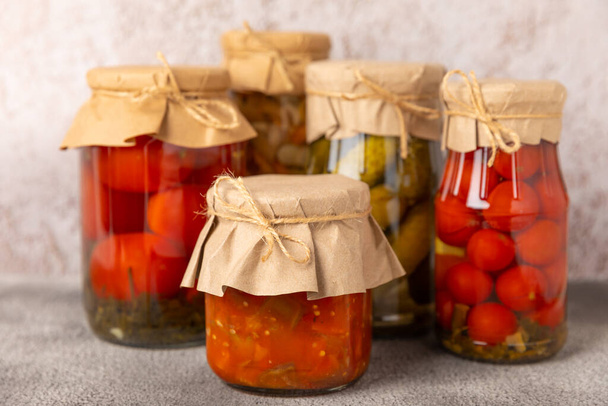 Preservation of vegetables in jars. fermentation products. Harvesting tomatoes and cucumbers, mushrooms, salads for the winter. Jars with pickled vegetables. marinated food. Stocks for the winter. Place for text. - Photo, image