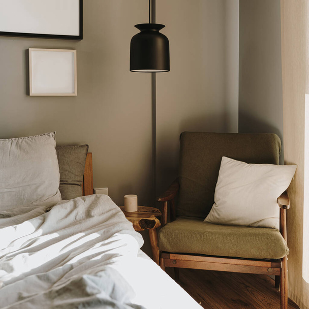 Эстетическая элегантная современная стильная концепция дизайна интерьера спальни. Уютная нейтральная скандинавская комфортная гостиная с мебелью, подвесной лампой, креслом. Постель из льняной ткани. Солнечные тени - Фото, изображение