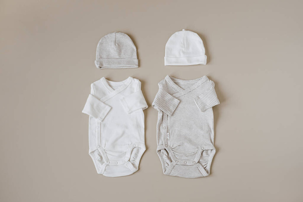 Hangulatos higiéniai ruhák és kiegészítők újszülött babának. Alapvető kosztümök, sapkák pasztell bézs háttérrel. Esztétikai minimalista baba divat kollázs - Fotó, kép