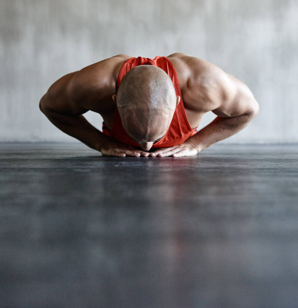 Está concentrado en 100. un hombre haciendo un ejercicio desafiante en el gimnasio - Foto, imagen
