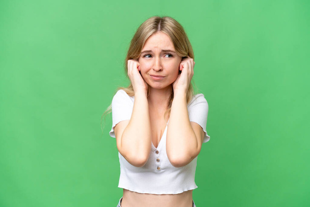 Молодая англичанка на изолированном фоне разочарована и закрывает уши - Фото, изображение