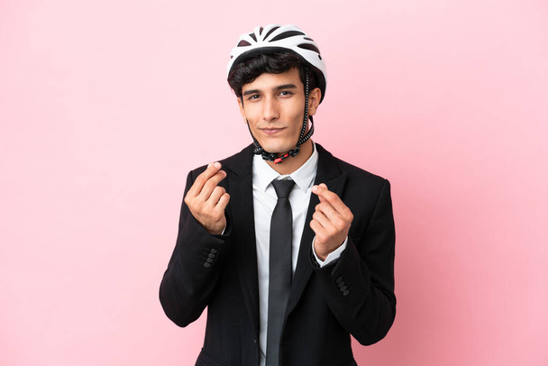 Argentinian businessman with bike helmen isoleted on pink background - Photo, Image