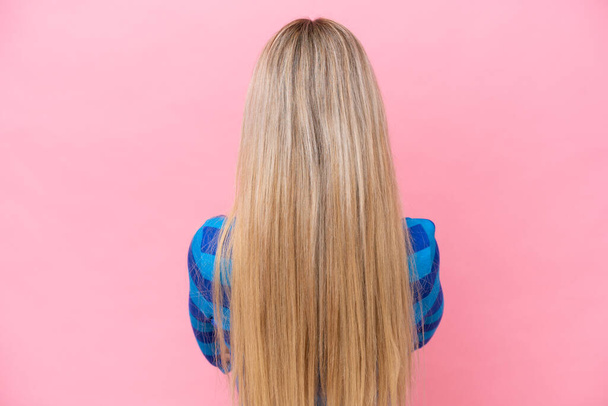 Pretty blonde woman isolated on pink background in back position - Foto, afbeelding