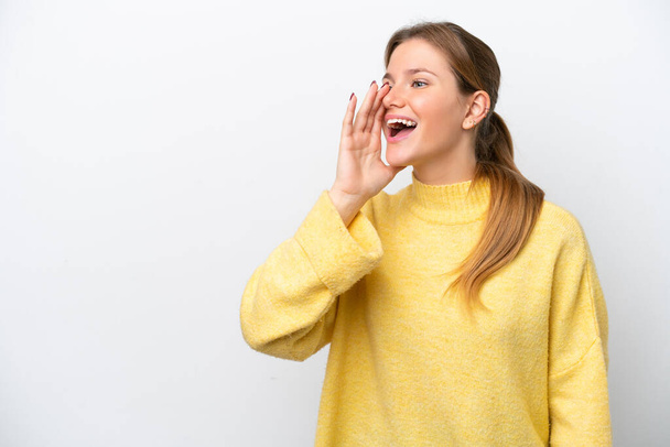 Mujer joven caucásica aislada sobre fondo blanco gritando con la boca abierta hacia un lado - Foto, Imagen