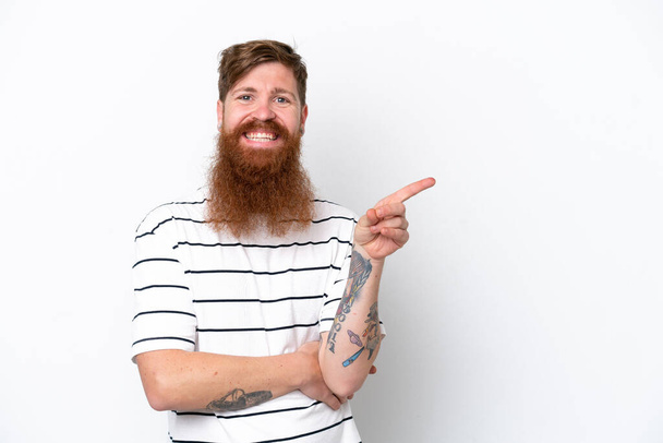 Redhead man with beard isolated on white background pointing finger to the side - 写真・画像