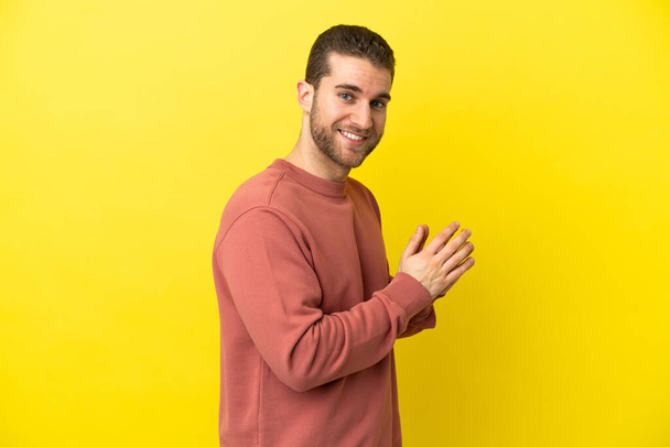 Handsome blonde man over isolated yellow background scheming something - Foto, imagen