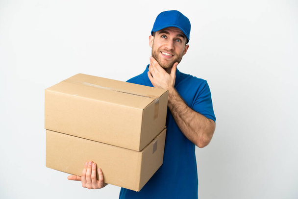Delivery férfi elszigetelt fehér háttér keres fel, miközben mosolyog - Fotó, kép