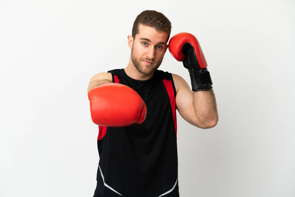 Schöner blonder Mann über isoliertem weißem Hintergrund mit Boxhandschuhen - Foto, Bild